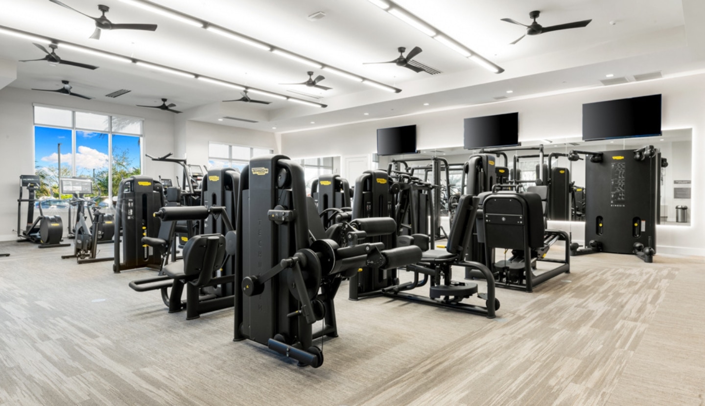 The state-of-the-art fitness center at Esplanade, rows of strength and cardio equipment in a bright, window-lined room